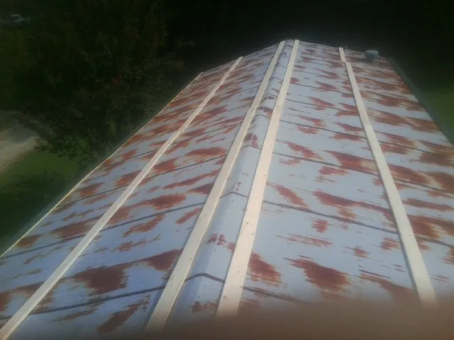 Rusted metal roof panels with new wood purlins before replacement — Storm Damage Roof Repair in Howe by Roofing Brothers