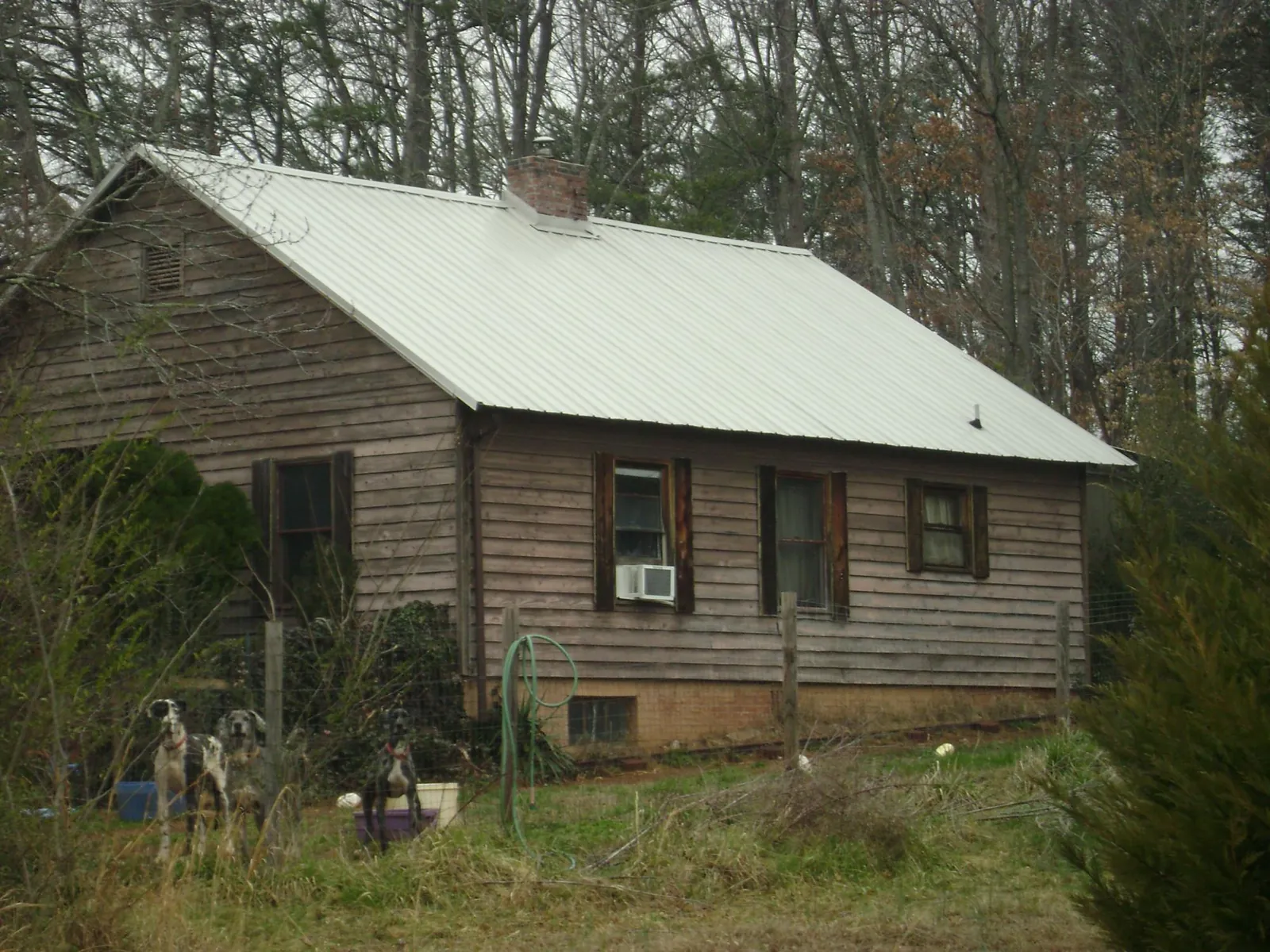 White metal roof on an old wood sided farmhouse, from a Metal Roof Installation job in Howe